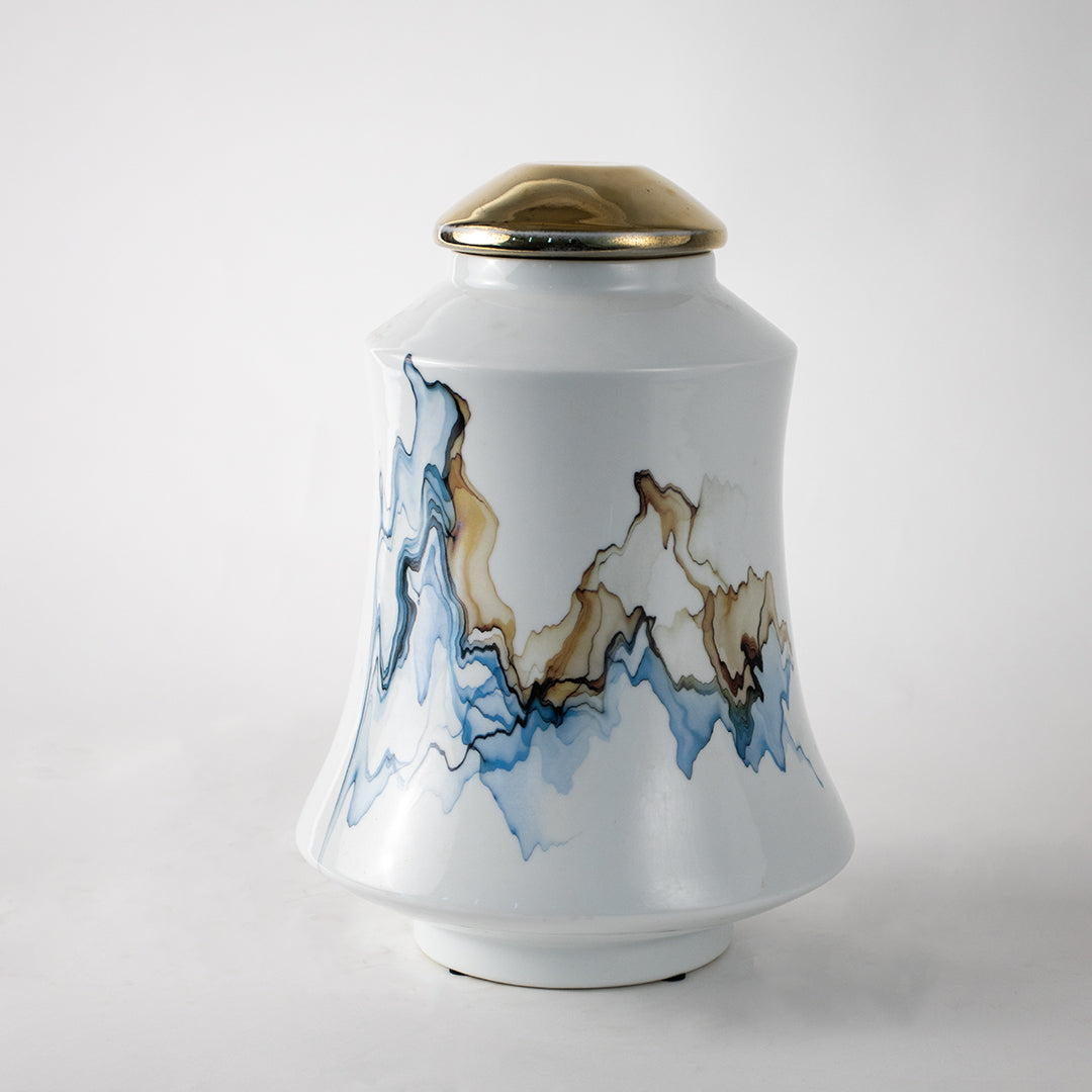 White ceramic decorative jar with blue wave artwork and gold lid for elegant tabletop styling and modern home decor.