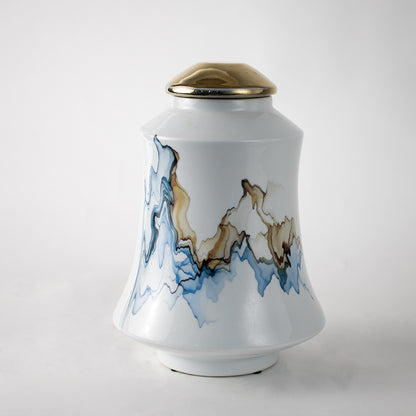 White ceramic decorative jar with blue wave artwork and gold lid for elegant tabletop styling and modern home decor.