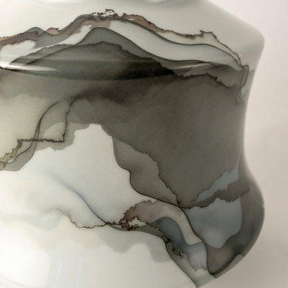 White ceramic jar with soft gray abstract swirl design displayed on plain background for elegant décor.