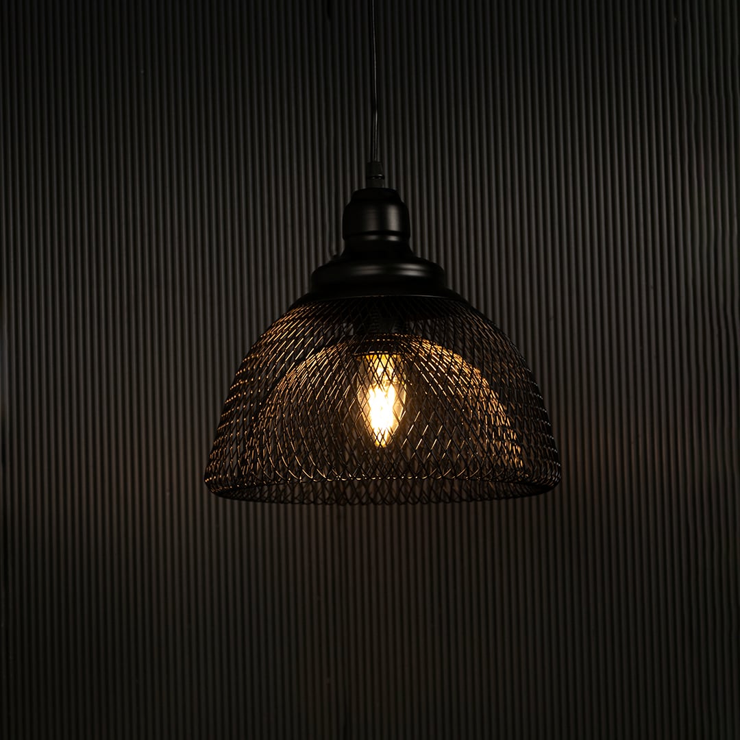 Elegant black mesh pendant light illuminated against dark background highlighting artistic industrial style and fine craftsmanship.
