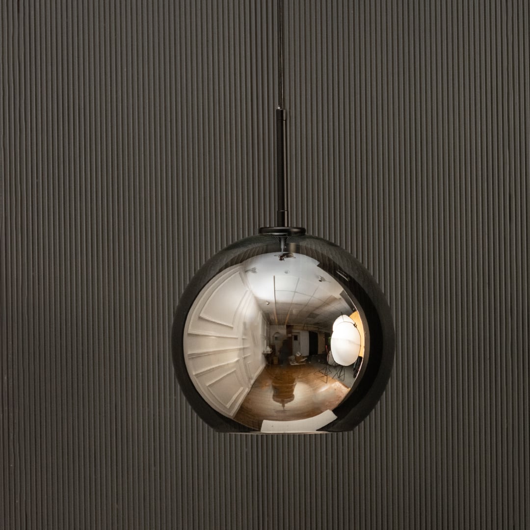 Smoked glass globe pendant light with black suspension sleek modern ceiling lamp perfect for dining and luxury living interiors.