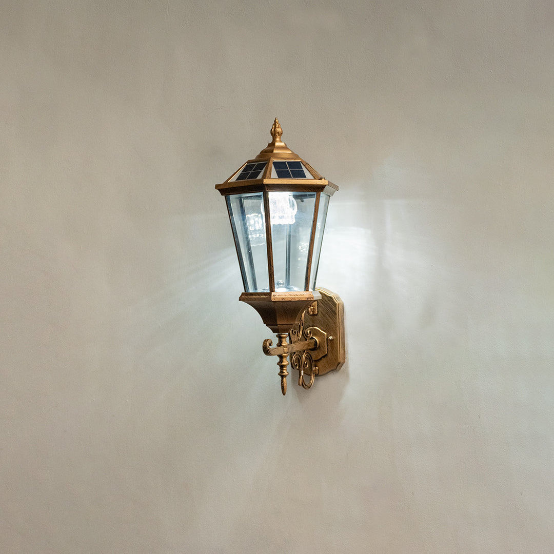 Vintage bronze outdoor wall light on white background with clear glass shade for elegant exterior decor.