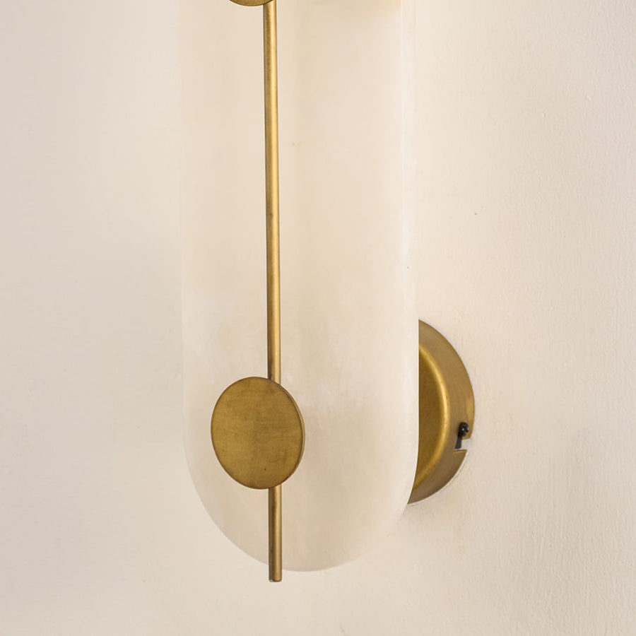 Closeup of white marble and gold metal wall light for premium bedroom and modern decor styling spaces.