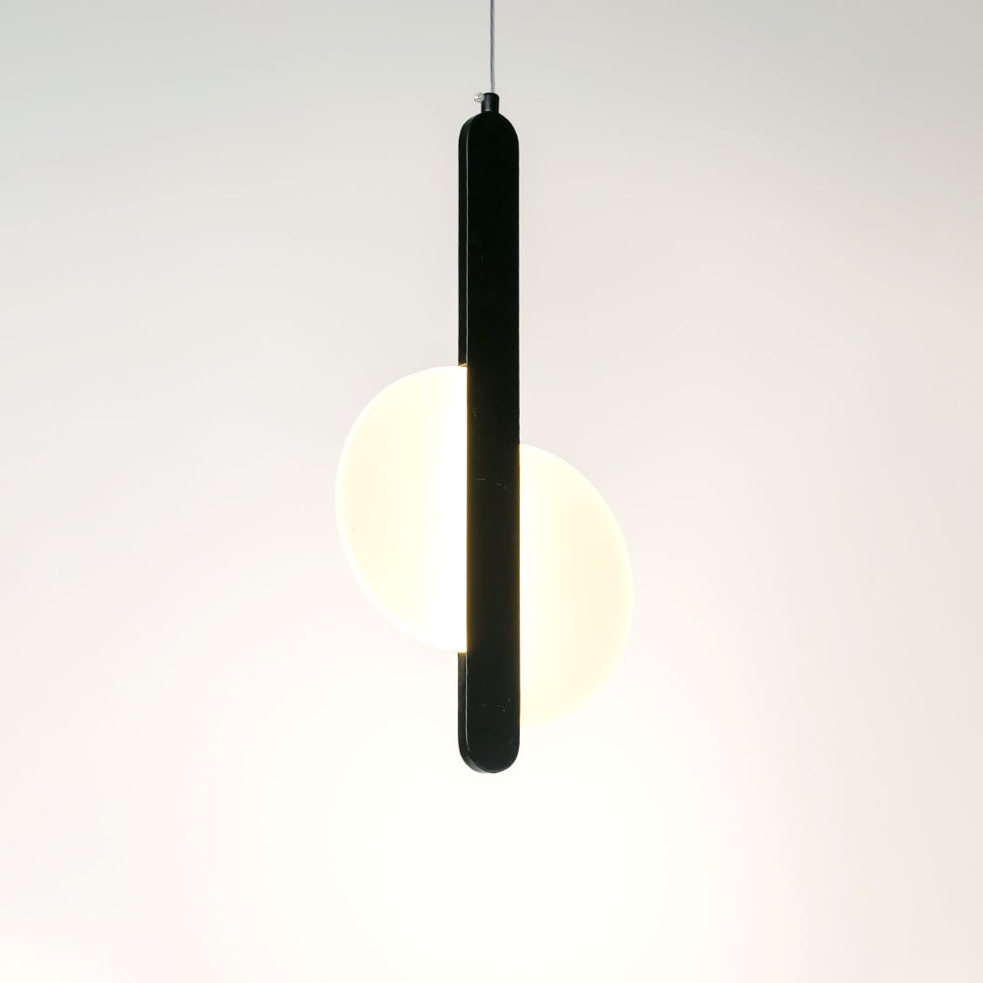 Black pendant light with integrated frosted diffuser casting warm illumination for stylish modern interiors.