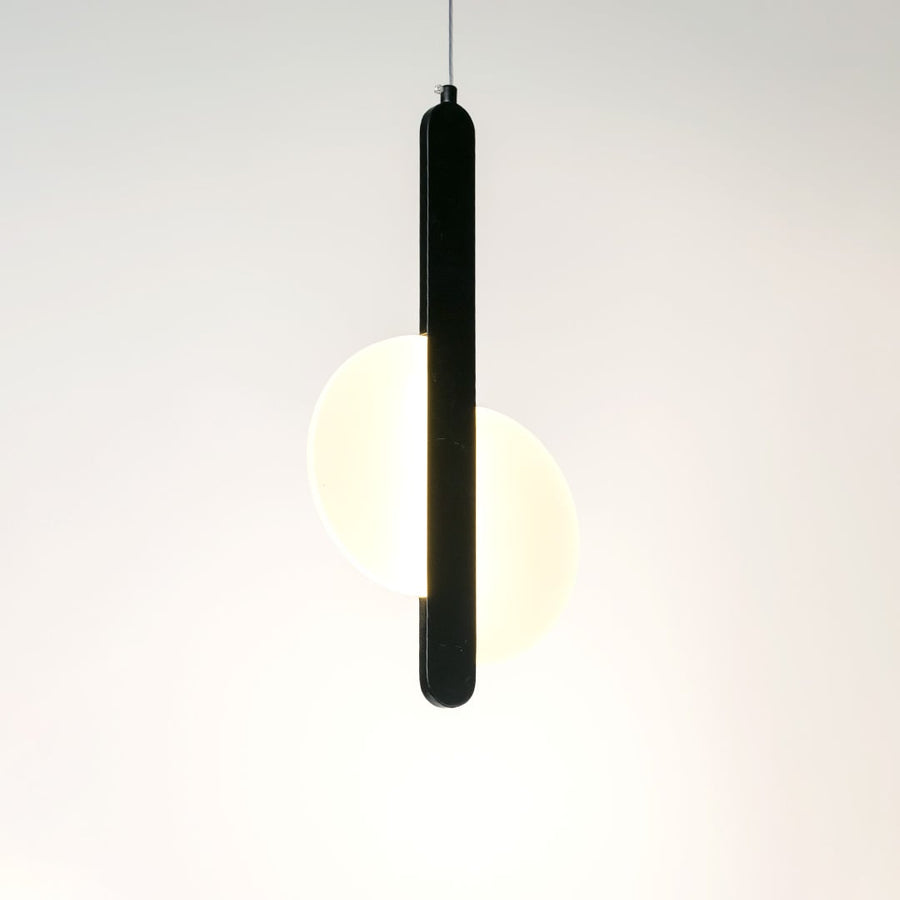 Black pendant light with integrated frosted diffuser casting warm illumination for stylish modern interiors.