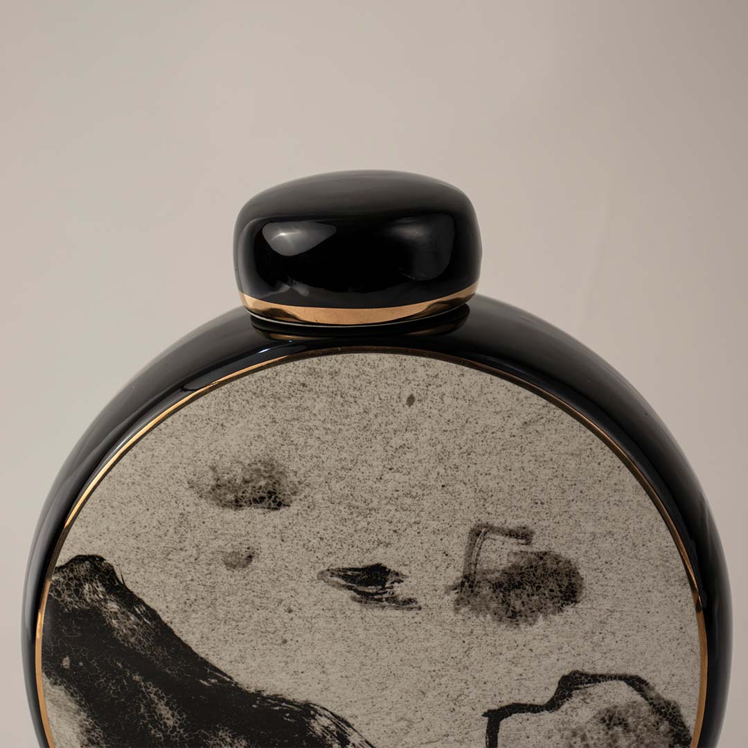 Closeup view of round black ceramic vase featuring detailed mountain pattern with glossy finish ideal for table styling.