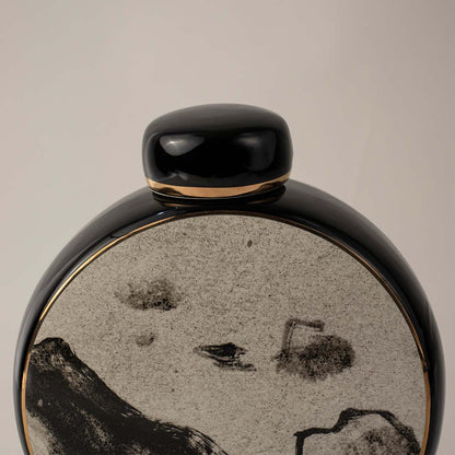 Closeup view of round black ceramic vase featuring detailed mountain pattern with glossy finish ideal for table styling.