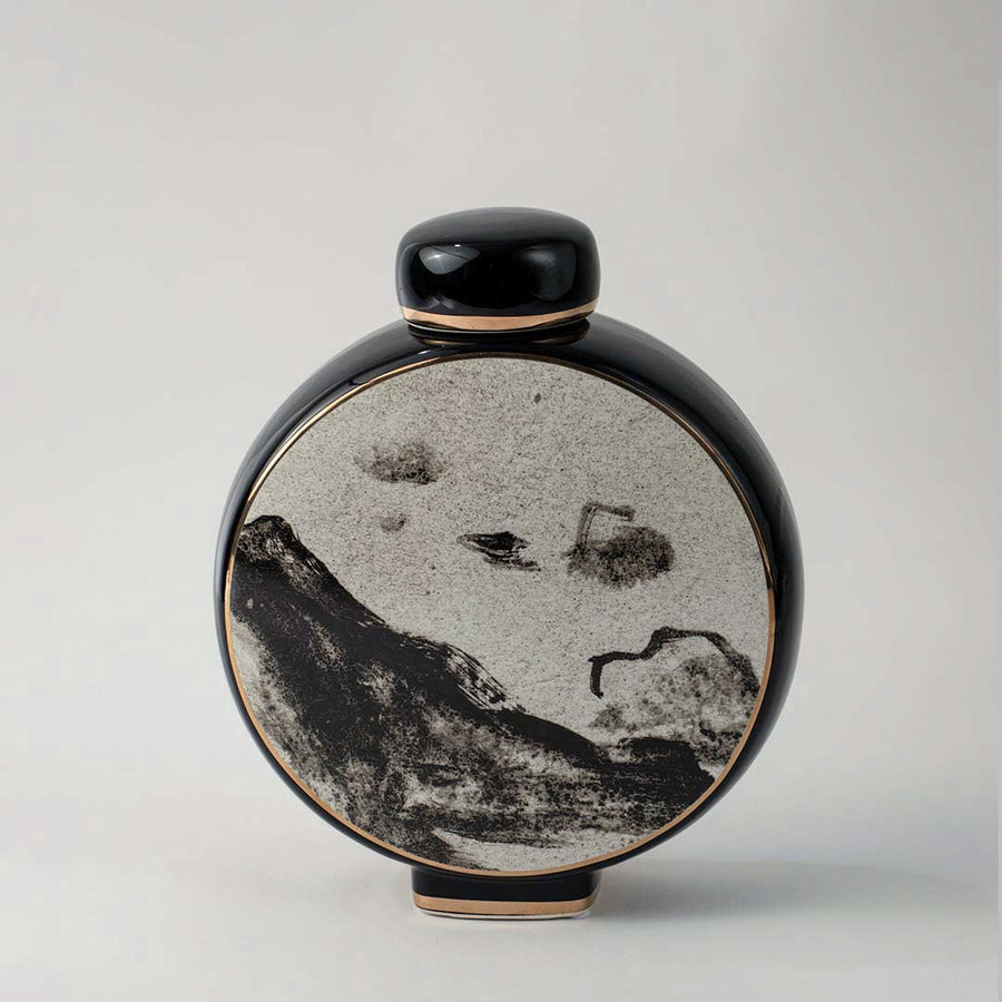 Round black and beige ceramic vase with abstract mountain artwork displayed on white background for home decoration.