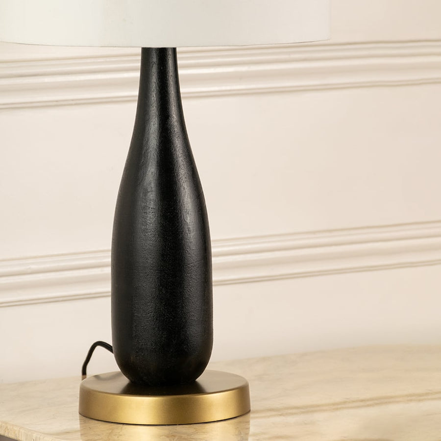 Black wood lamp base with brass accent detailing showcasing refined craftsmanship and timeless decorative styling.