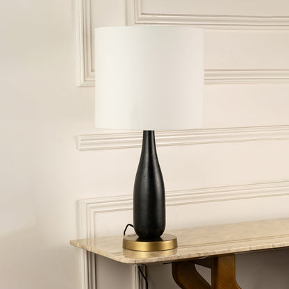 White fabric shade table lamp with black wood base and brass accents for elegant bedside and console table decor.