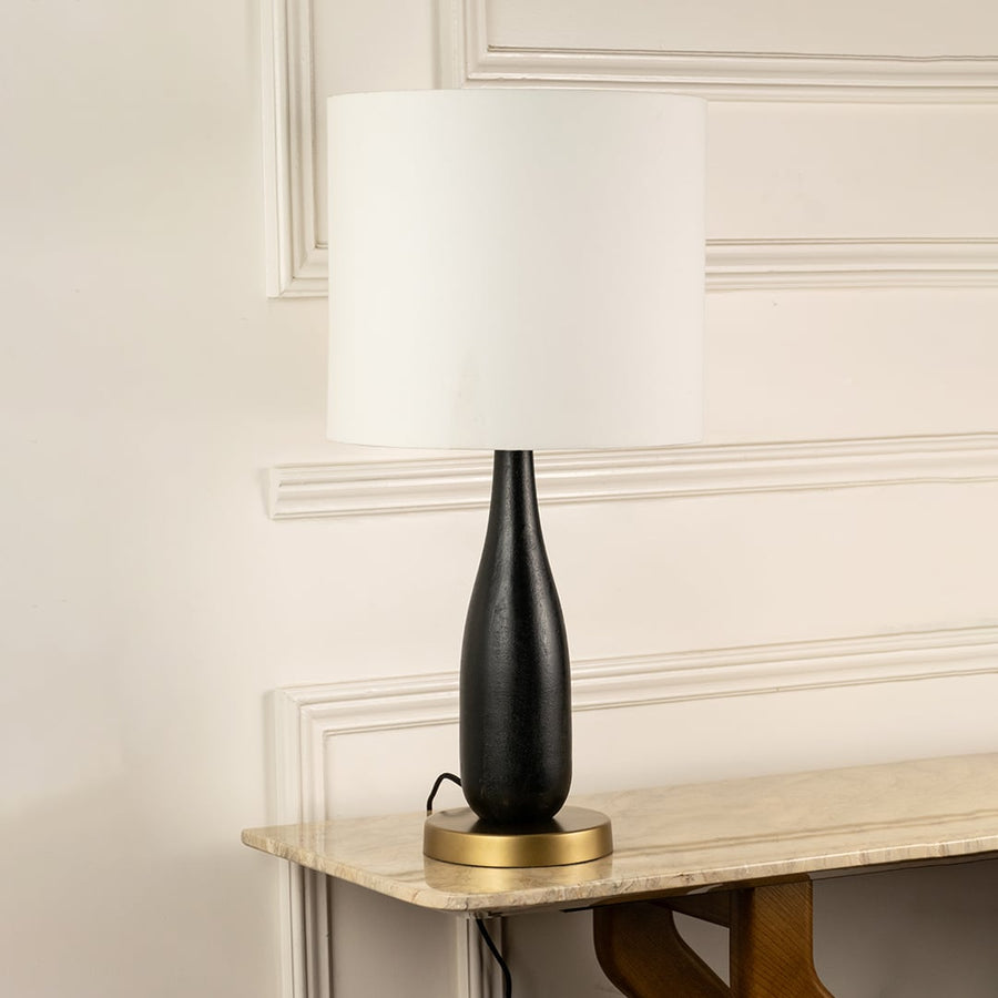 White fabric shade table lamp with black wood base and brass accents for elegant bedside and console table decor.