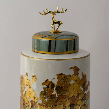White ceramic jar with deer lid and botanical artwork placed on white surface against neutral background showcasing luxury decorative home decor accent.