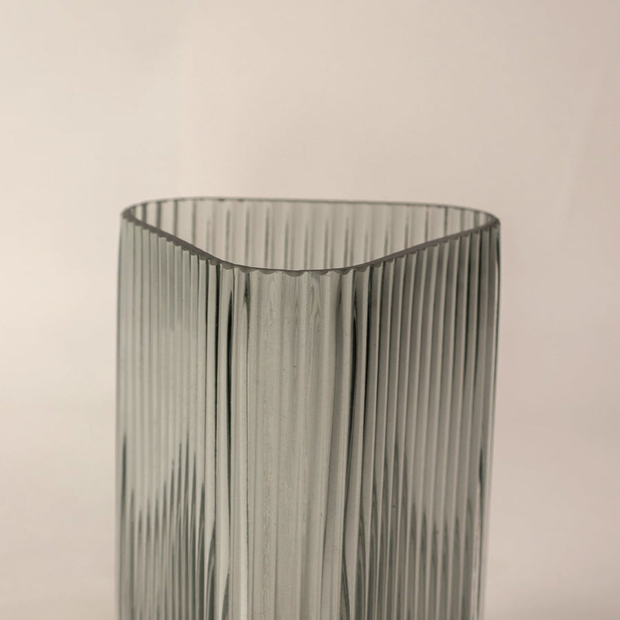 Closeup of ribbed grey glass vase highlighting its vertical textured design and sleek transparent finish for a refined modern look.