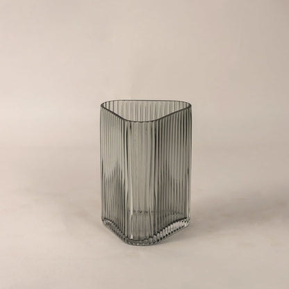 Side angle view of ribbed grey glass vase displaying curved top edge and fine linear pattern for an elegant decorative appeal.