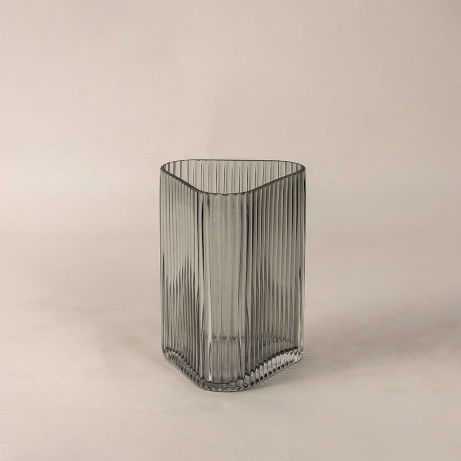 Side angle view of ribbed grey glass vase displaying curved top edge and fine linear pattern for an elegant decorative appeal.