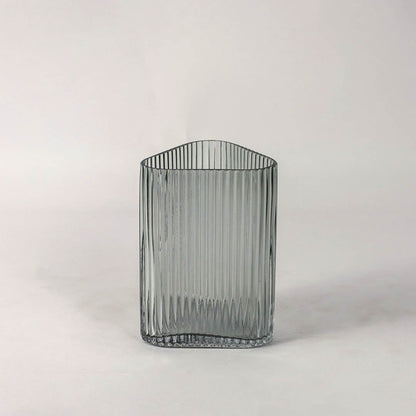 Textured grey glass vase with vertical grooves and rounded corners placed on plain white surface for a clean modern presentation.