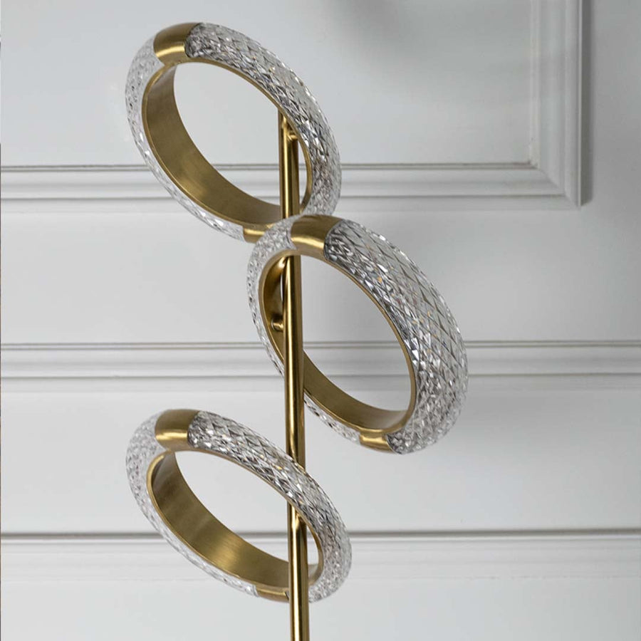 Closeup view of the floor lamp showcasing the gold globe shade and the sleek black base highlighting the high-end design details.