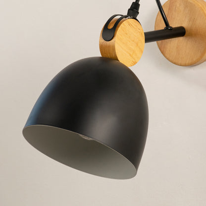 Closeup of black metal wall light with wooden backplate highlighting matte finish and design detail for modern interior wall decor.