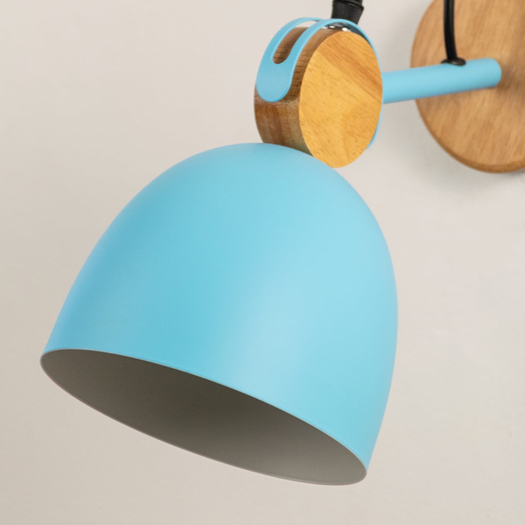 Detailed macro shot of a blue dome wall lamp focusing on the natural wood swivel hinge assembly and matching bracket.