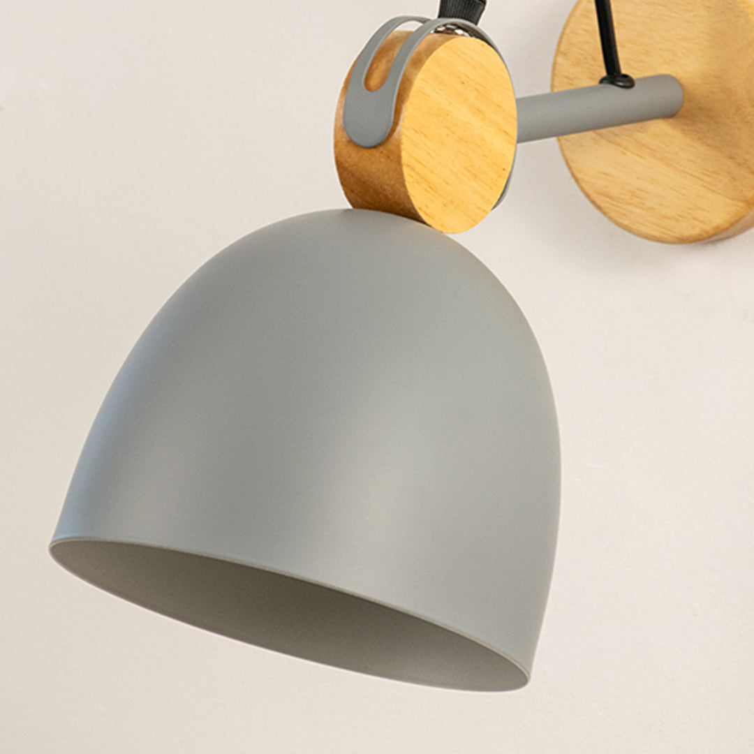 Closeup of grey metal wall light shade with wooden mount showing smooth finish and modern design for interior wall decor styling.