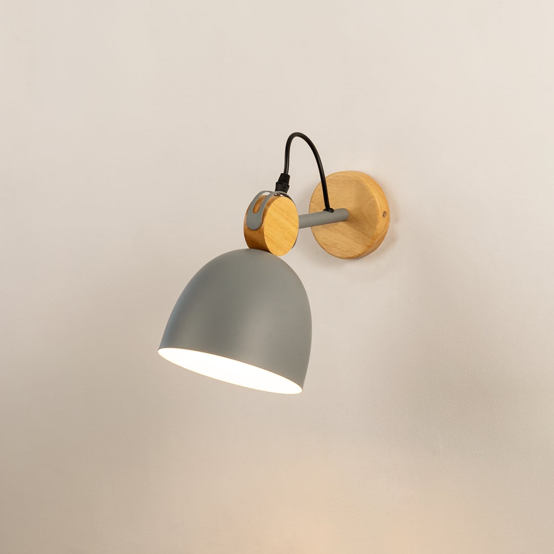 Nordic matte grey and natural wood dome wall sconce turned on against a plain off white background surface wall.