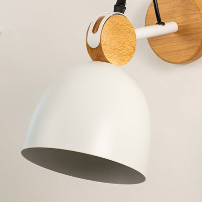 Detailed macro shot of a white dome wall lamp focusing on the natural wood swivel hinge assembly and metal mount bracket.