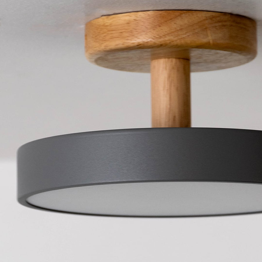 Closeup view of the ceiling light showing the natural wood texture and smooth grey shade with a clean minimal finish.