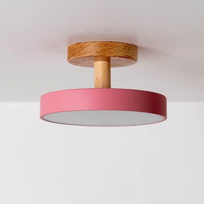 Ceiling light displayed off on a plain white background highlighting the wooden mount and pink shade in a minimal modern design.