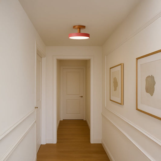 Modern ceiling light shown in a simple room setting with a natural wood mount and soft pink shade adding a warm minimal touch.