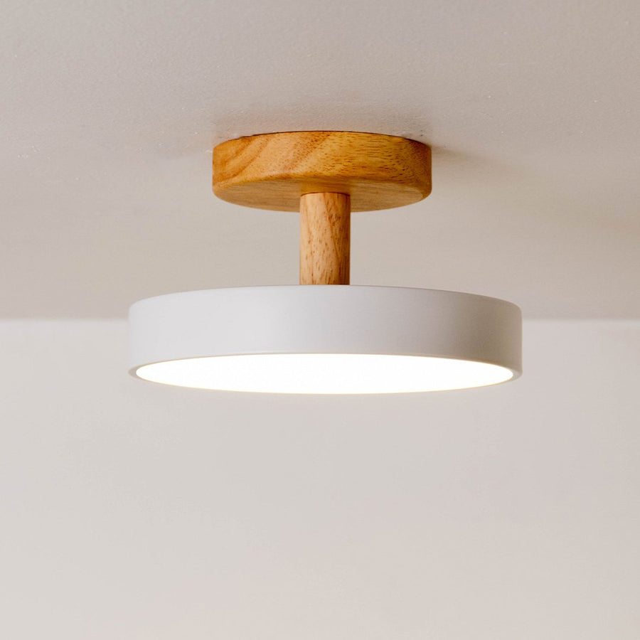 Closeup of white metal and natural wood ceiling light for Scandinavian interior and modern decor styling spaces.