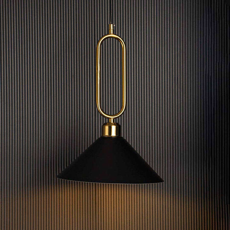 Black conical pendant ceiling light with gold metal frame glowing warmly against black background creating modern luxury interior.