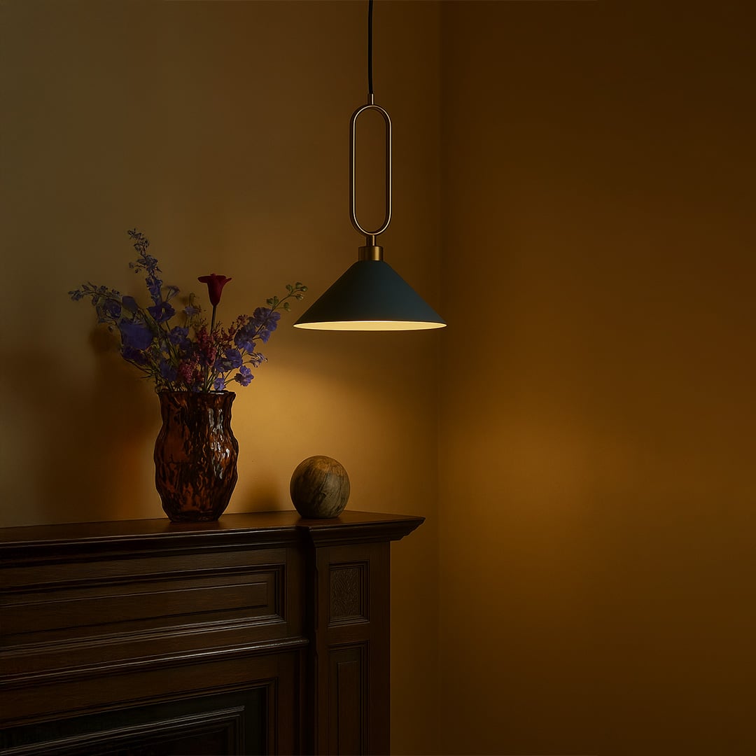 Blue conical pendant ceiling light with gold frame glowing warmly above kitchen counter creating modern lifestyle atmosphere.