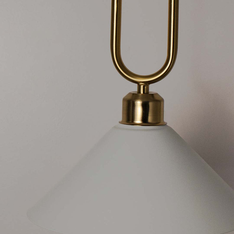 Closeup of white metal pendant light with polished gold loop detailing showcasing refined craftsmanship and elegance.