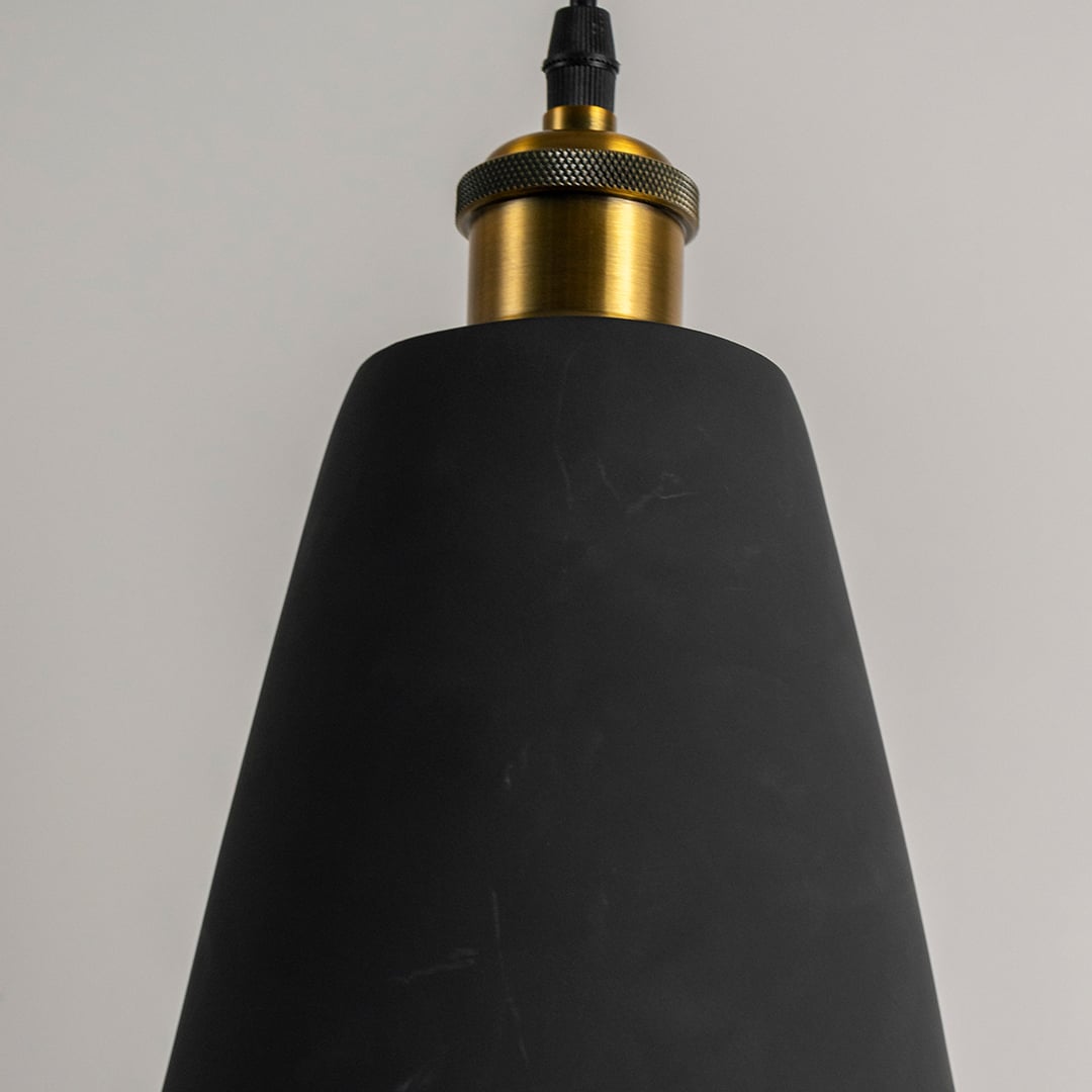 Closeup of black cone pendant light turned off showing smooth matte finish and detailed brass top for modern lighting design.