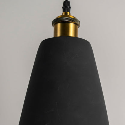Closeup of black cone pendant light turned off showing smooth matte finish and detailed brass top for modern lighting design.