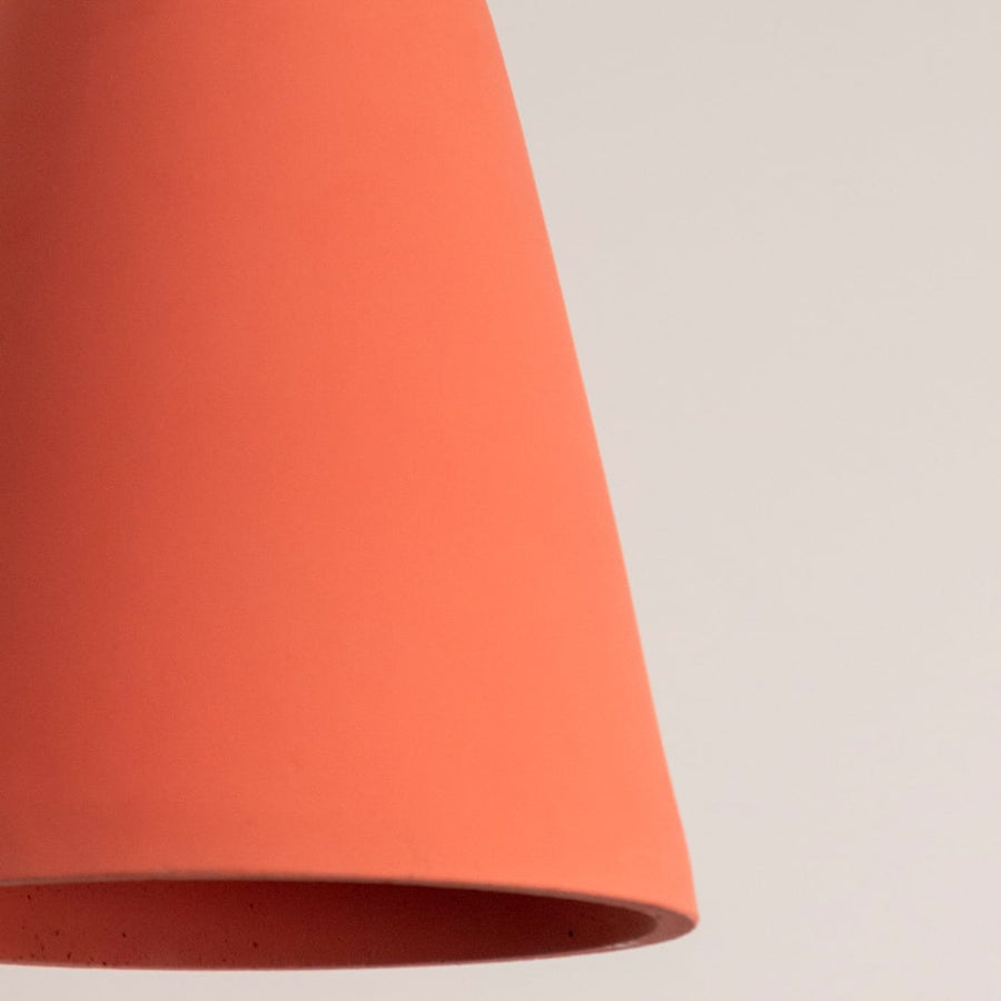 Terracotta cone pendant light showcasing a clean conical shape with a modern matte finish and brass fitting.