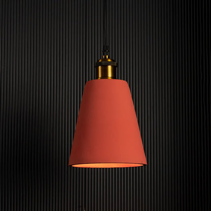 Terracotta cone pendant lamp glowing against a dark background emphasizing its elegant color and warm lighting.