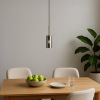 Slim chrome pendant light suspended above dining table adding modern elegance and ambient charm.