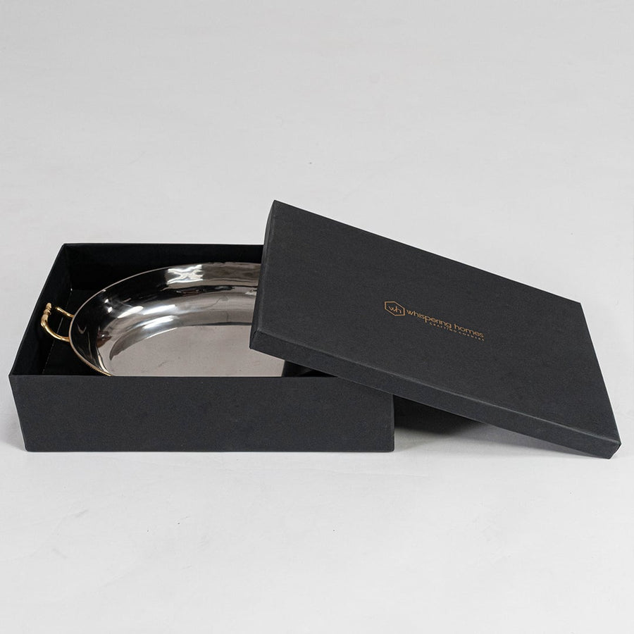 Stainless steel decorative tray with gold handles and raised feet shown at angle on plain white background.