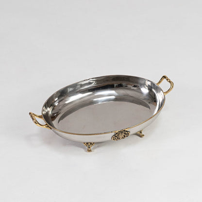 An elegant oval metal bowl with decorative gold accents displayed on a clean white background showcasing its smooth reflective surface and curved profile.