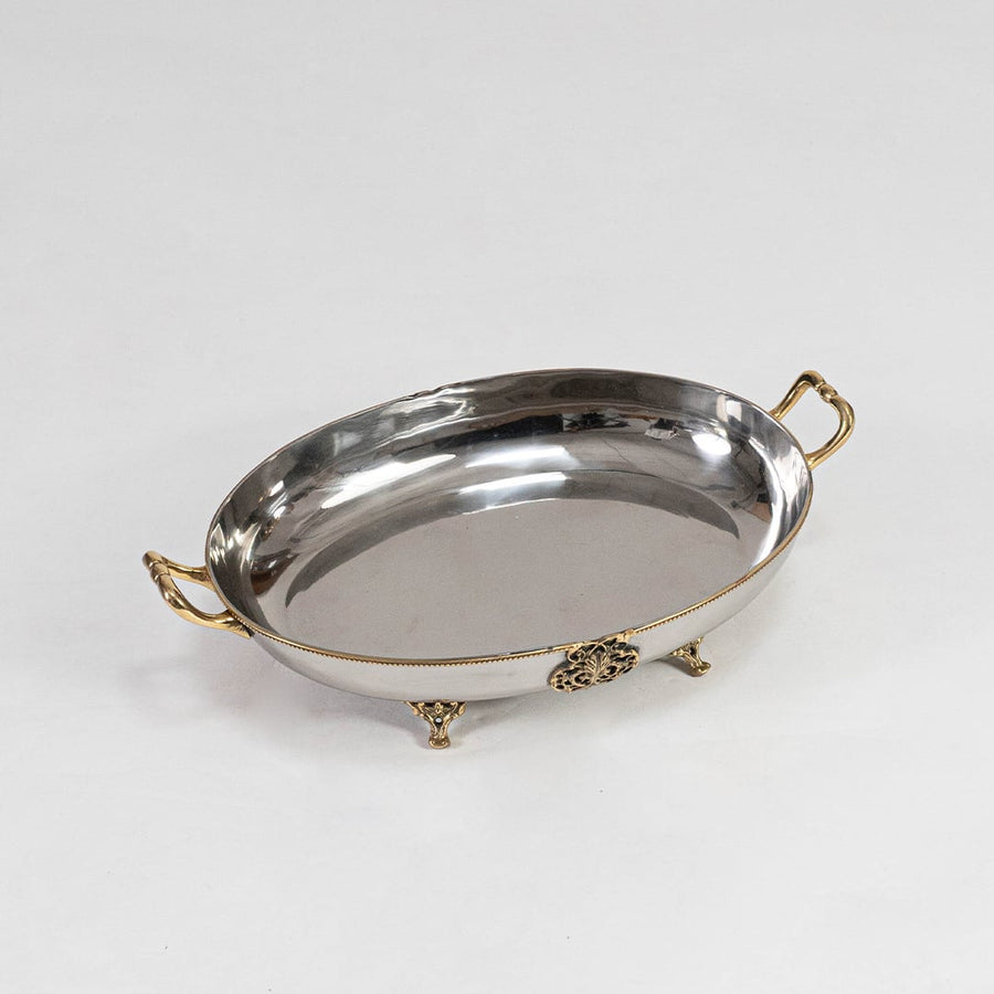 An elegant oval metal bowl with decorative gold accents displayed on a clean white background showcasing its smooth reflective surface and curved profile.