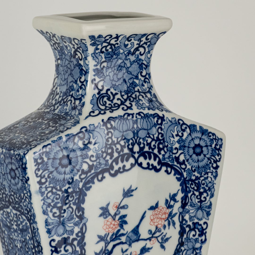 Closeup of blue and white ceramic decorative vase with floral artwork showcasing premium craftsmanship and styling.