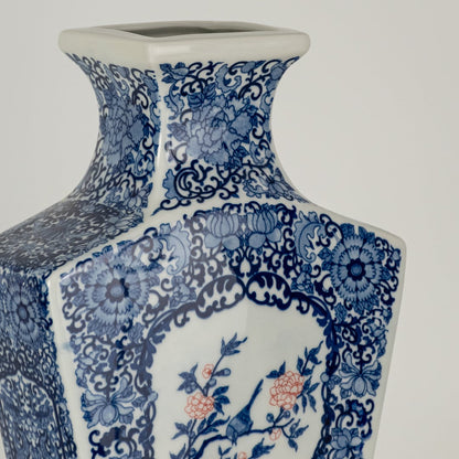 Closeup of blue and white ceramic decorative vase with floral artwork showcasing premium craftsmanship and styling.