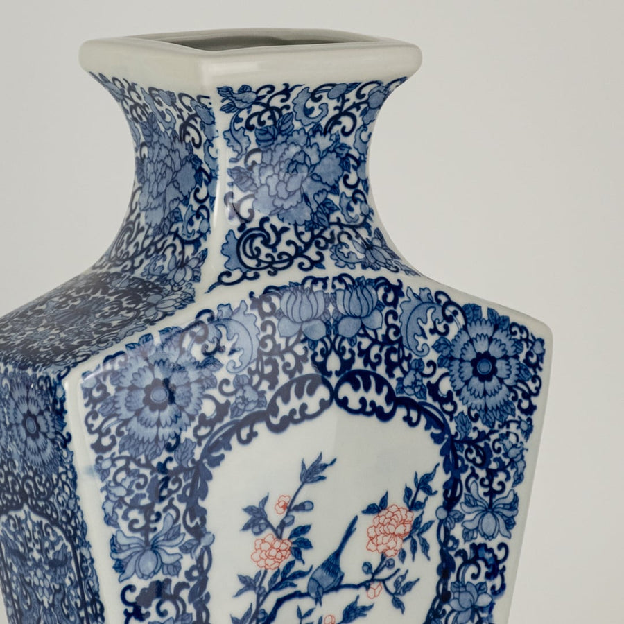 Closeup of blue and white ceramic decorative vase with floral artwork showcasing premium craftsmanship and styling.