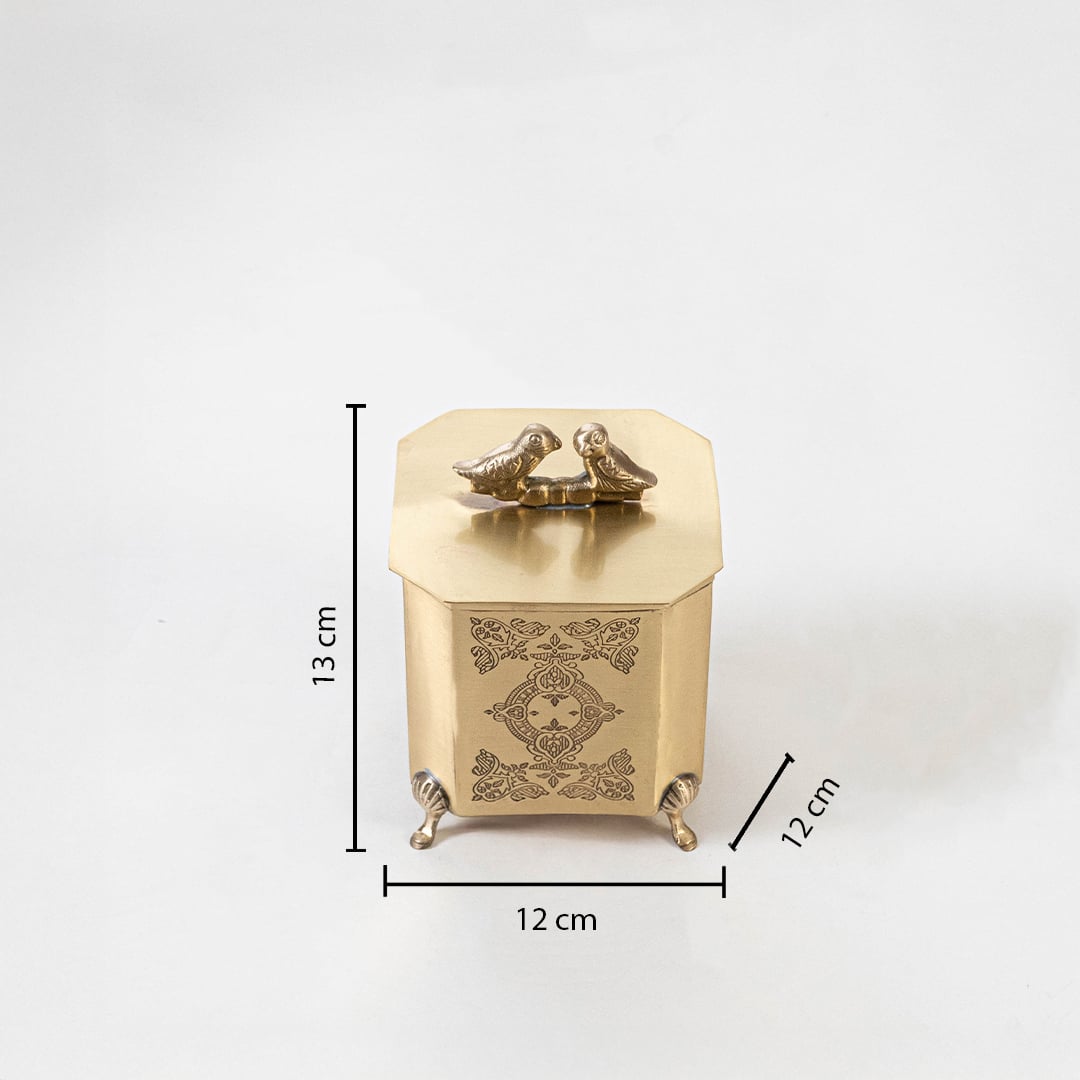 A brass decor box with bird handle shown on a white background displaying its dimensions clearly as 12 cm width 12 cm depth and 13 cm height.