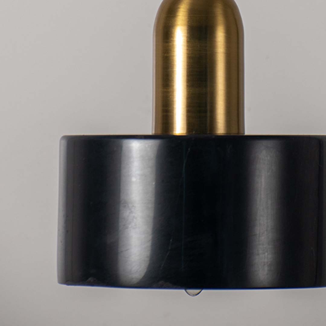 Closeup of table lamp base showing matte black shade gold metal stem and refined finish for modern decorative lighting.