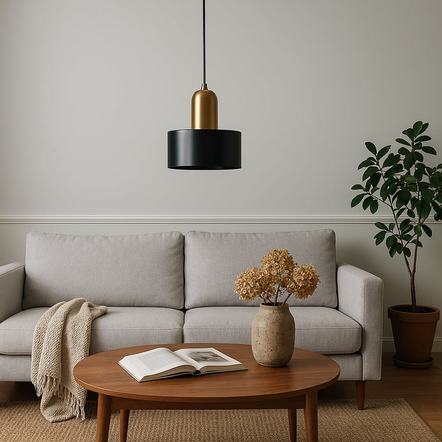 Modern black and gold pendant ceiling light hanging above sofa in stylish living room interior creating luxury lifestyle look.