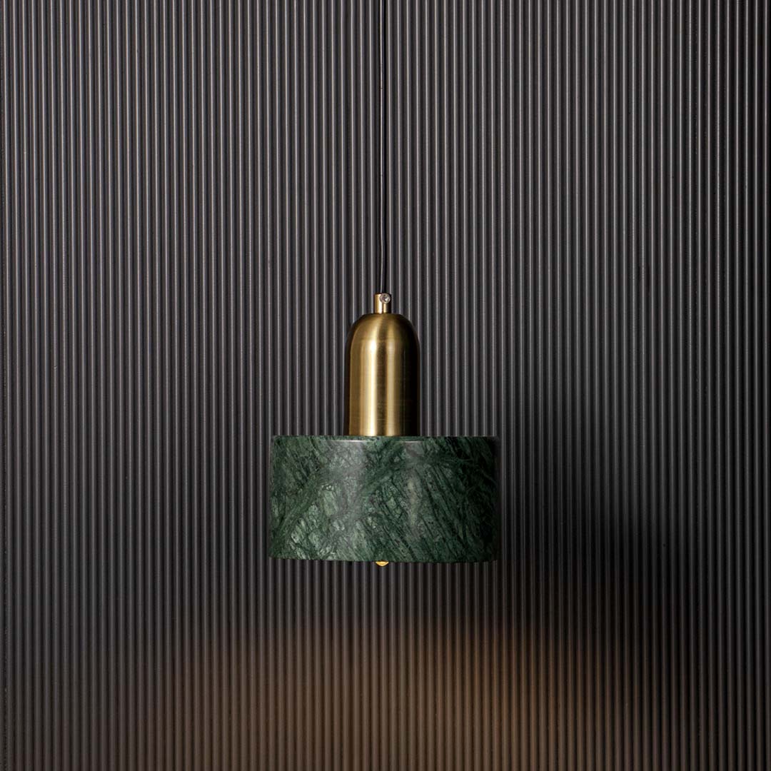 Stylish green marble and gold pendant ceiling light glowing beautifully against black background creating modern luxury vibe.