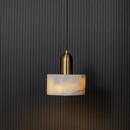 White marble and gold cylindrical pendant ceiling light illuminated beautifully against black background for luxury decor.