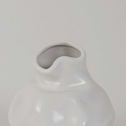 Closeup of white ceramic vase showing smooth glossy texture and curved shape ideal for minimalist decor aesthetics.